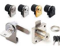 Picture four cam locks one black one gold one chrome and one satin chrome underneath satin chrome cam lock with horizontal rear locking bar and silver ket protuding from lock nearby chrom desk lock with locking tongue protruting from top of lock  