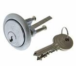 Picture Lockwood 201 cylinder chrome cylindrical lock face with keyway round chrome ring around lock face two screws and lock tail protruding from back of lock two brass keys on a key ring underneath